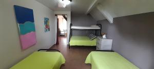 2 camas en una habitación con sábanas verdes en Casa Grande Retiro para grupos en Cerro Azul