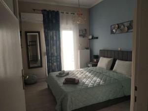 ein Schlafzimmer mit einem Bett und einem großen Fenster in der Unterkunft Athens view apartment near Metro station Agia Marina in Athen