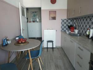 cocina con mesa, sillas y fregadero en Athens view apartment near Metro station Agia Marina, en Atenas
