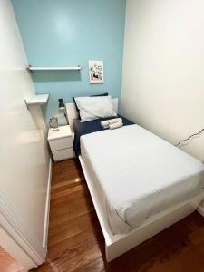 a small bedroom with a bed and a blue wall at Beautiful private rooms in a shared apartment upper west side in New York