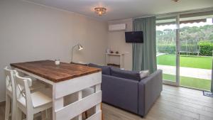 a living room with a sofa and a table and a couch and a television at Holidays en Arenys de Mar y Montaña in Arenys de Mar