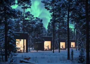 une maison dans les bois la nuit dans la neige dans l'établissement Polaris Villas, à Muonio