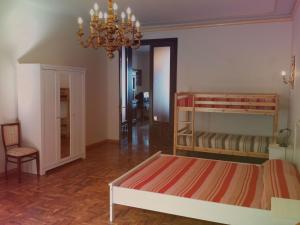 een slaapkamer met een bed en een kroonluchter bij Perla di Naxos in Giardini Naxos