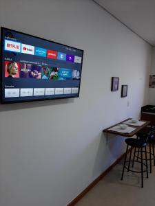 a tv hanging on a wall in a room at Alpes Flats in Campos do Jordão