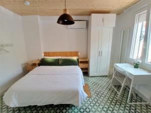Un dormitorio con una cama y una mesa dentro. en Casa Valparaíso Málaga - 350m from beach, en Málaga