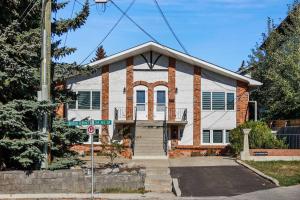 a white and red brick house on a street at Roxboro #1 Premium Central 3BR Home Parking, Wifi in Calgary