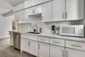 Roxboro #1 Premium Central 3BR Home Parking, Wifi في كالغاري: مطبخ أبيض مع خزائن بيضاء وأجهزة