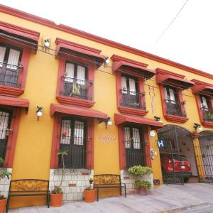 Edificio amarillo y rojo con ventanas y balcones en Hotel Doña Alicia en Oaxaca de Juárez