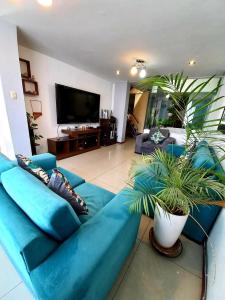 a living room with a blue couch and a tv at Mandala Rooms & Services in Arequipa