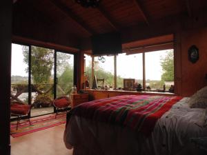 1 dormitorio con cama y ventana grande en Maipo River House: los Jardines del Maipo, en San Antonio