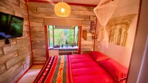 1 dormitorio con 1 cama roja en una habitación con TV en Maipo River House: los Jardines del Maipo, en San Antonio