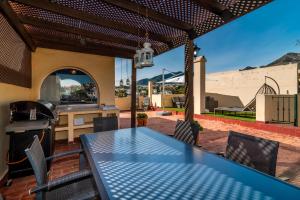 een patio met een tafel en een grill bij VB Fantastic 3BDR Duplex with large terrace in Benalmádena