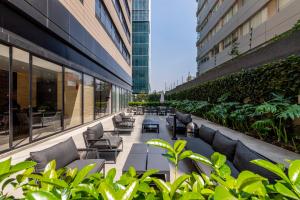 an outdoor patio with couches and plants in a building at Neuchatel Polanco by RentinBA in Mexico City
