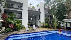 a child playing in a swimming pool in front of a building at Almarea Vacation Condo in Playa del Carmen