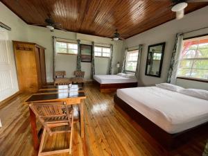 a bedroom with two beds and a table in it at Sea n sun Guest House in Caye Caulker
