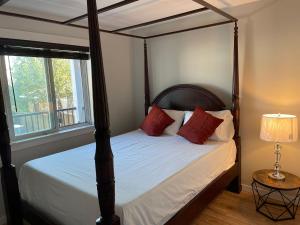 um quarto com uma cama de dossel com almofadas vermelhas em Sooke Vacation suite em Sooke