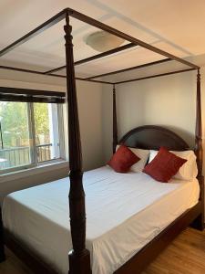 1 dormitorio con cama con dosel y almohadas rojas en Sooke Vacation suite en Sooke