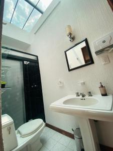 a bathroom with a sink and a toilet and a mirror at Cozy Private Room in Mexico City