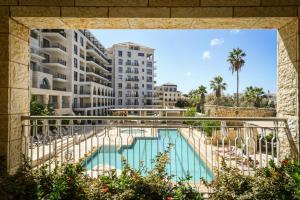 von einem Balkon eines Gebäudes mit Poolblick in der Unterkunft Breathtaking 3 BR Apt w Sea View in Central Jaffa by Sea N' Rent in Tel Aviv