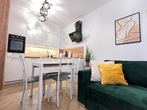 cocina y sala de estar con sofá verde en Apartamenty pod Wieżą - Tatarska, en Przemyśl