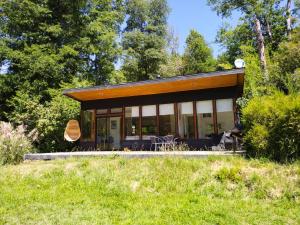 a small house in a field with trees at Cabañas Nordic lodge in Recinto