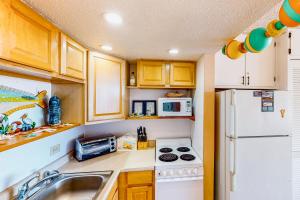 a kitchen with wooden cabinets and a white refrigerator at Shorely Suite in Atlantic Beach
