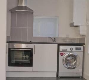 cocina con lavavajillas y lavadora en Aberdeen Serviced Apartments: Charlotte street en Aberdeen