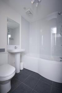 La salle de bains blanche est pourvue de toilettes et d'un lavabo. dans l'établissement Aberdeen Serviced Apartments: Charlotte street, à Aberdeen