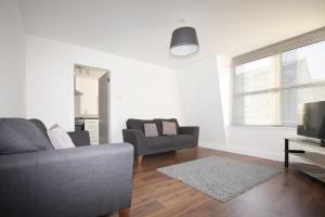 ein Wohnzimmer mit einem Sofa und einem TV in der Unterkunft Aberdeen Serviced Apartments: Charlotte street in Aberdeen