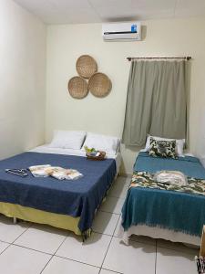 1 Schlafzimmer mit 2 Betten und einem Fenster in der Unterkunft Bom Sossego Pousada DG in Delmiro Gouveia