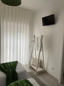 ein Schlafzimmer mit einem Bett und einem TV an der Wand in der Unterkunft ArouceHostel in Lousã