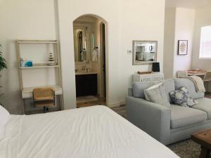 uma sala de estar com uma cama e um sofá em Beautiful Private Casita/Guesthouse w/ Kitchen, Access to Pool/Spa em Goodyear