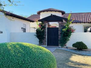 una casa con una puerta negra y una valla en Beautiful Private Casita/Guesthouse w/ Kitchen, Access to Pool/Spa, en Goodyear