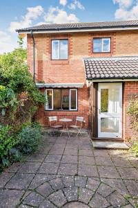 a brick house with a patio in front of it at Rowan Cottage in Barton on Sea