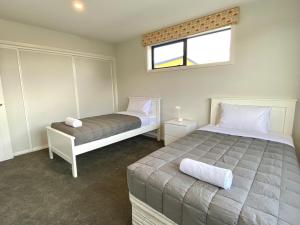 um quarto com 2 camas e uma janela em Stylish, Tasteful in Totara em Twizel
