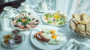 une table blanche avec des assiettes de produits pour le petit-déjeuner dans l'établissement Andersia Hotel & Spa Poznan, a member of Radisson Individuals, à Poznań