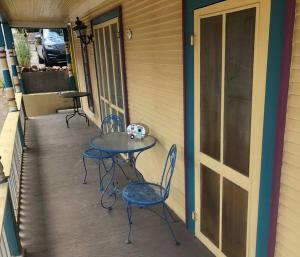 2 sillas y una mesa en el porche de una casa en Boho hip bungalow in Old Bisbee en Bisbee