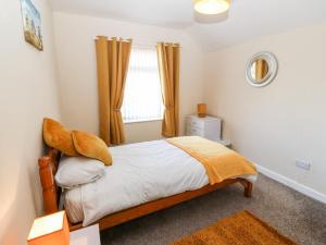 a bedroom with a bed and a window at Swn Y Mor in Caernarfon