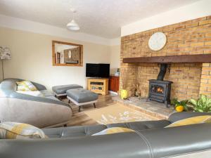 a living room with couches and a brick fireplace at Dove's Nest in Great Yarmouth