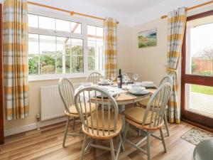a dining room with a table and chairs and windows at Dove's Nest in Great Yarmouth