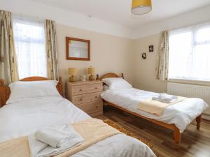 1 dormitorio con 2 camas, vestidor y ventanas en Dove's Nest en Great Yarmouth