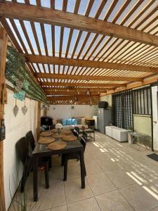 eine Terrasse mit einem Tisch und Stühlen unter einer Holzdecke in der Unterkunft CASA AGRADABLE in Santiago