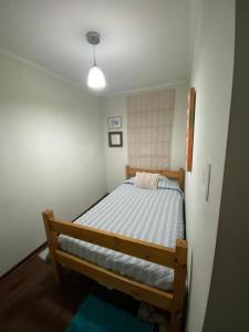 ein Schlafzimmer mit einem Holzbett in einem Zimmer in der Unterkunft CASA AGRADABLE in Santiago