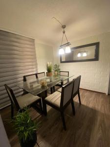 a dining room with a glass table and chairs at CASA AGRADABLE in Santiago +6 photos