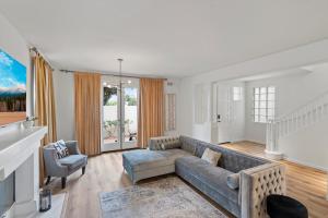ein Wohnzimmer mit einem Sofa und einem Stuhl in der Unterkunft The Goldenwest Ocean view home w jacuzzi AC Bikes newly remodeled in Huntington Beach