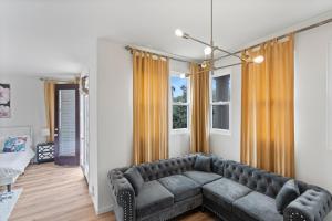 ein Wohnzimmer mit einem Sofa und einem Fenster in der Unterkunft The Goldenwest Ocean view home w jacuzzi AC Bikes newly remodeled in Huntington Beach