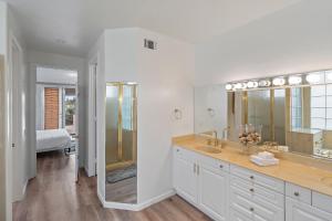 baño blanco con ducha y lavamanos en The Goldenwest Ocean view home w jacuzzi AC Bikes newly remodeled, en Huntington Beach