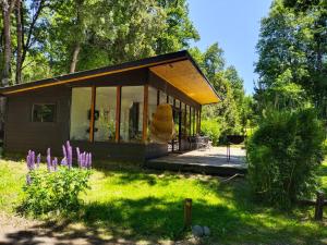 ein kleines Haus inmitten eines Gartens in der Unterkunft Cabañas Nordic lodge in Chillán