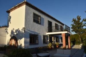 un edificio bianco con finestre nere e un patio di CASA RURAL HUERTA DEL MEDIO a Granada