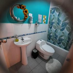 a bathroom with a sink and a toilet and a mirror at Hostal Brisa Marina in Paracas